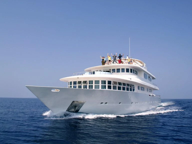 Beachfront view of waves breaking over shallow reef in Maldives – Atoll Travel