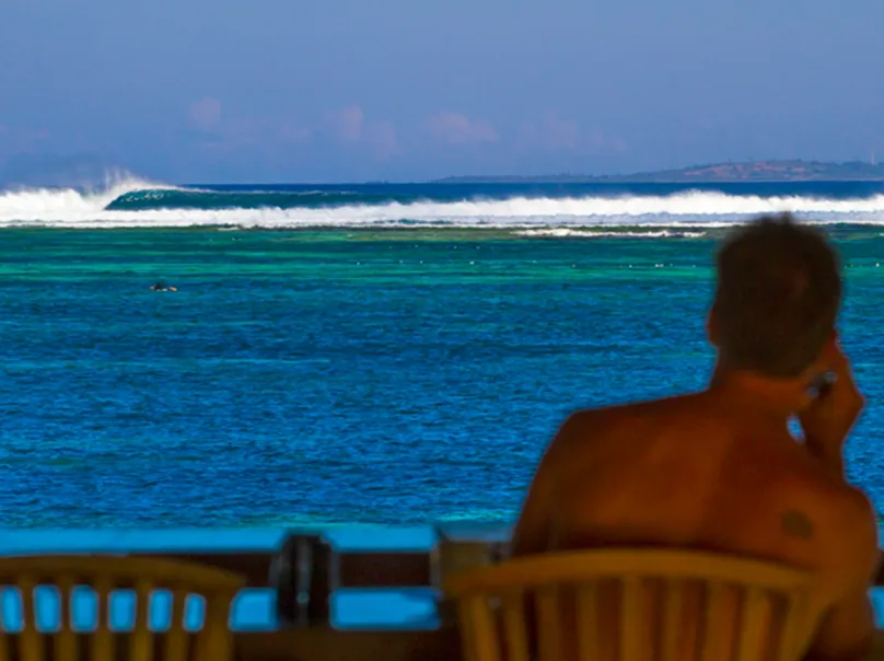 Wide shot of surfers waiting for the perfect wave at Maldives surf spot – Atoll Travel