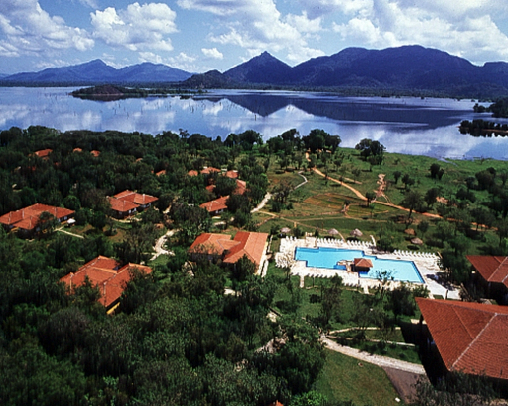 Surfers paddling toward waves at a tropical Maldives surf destination – Atoll Travel
