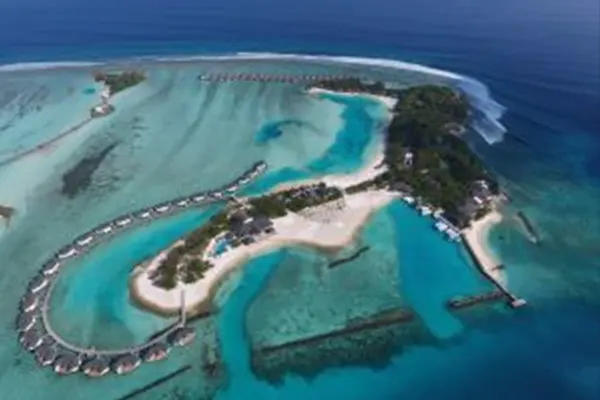 Overhead aerial of surfers riding waves near tropical island reef, Maldives – Atoll Travel