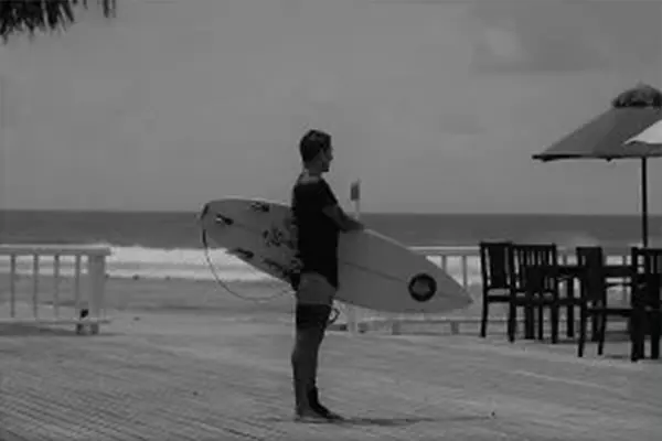 Surfer Alex riding wave with tropical scenery in Maldives – Atoll Travel