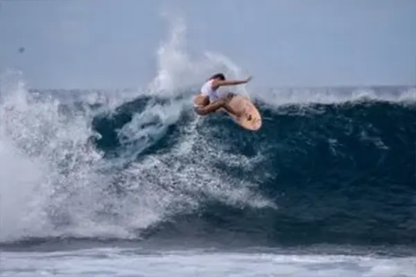 Action shot of Bethany Hamilton surfing large wave, Maldives – Atoll Travel