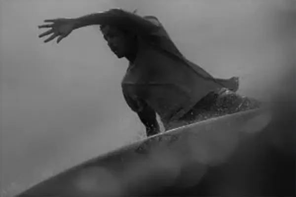 Surfer Miguel carving wave under bright tropical sunlight, Maldives – Atoll Travel