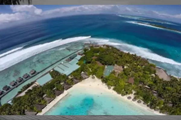 Surfers riding waves in Maldives with tropical scenery – Atoll Travel