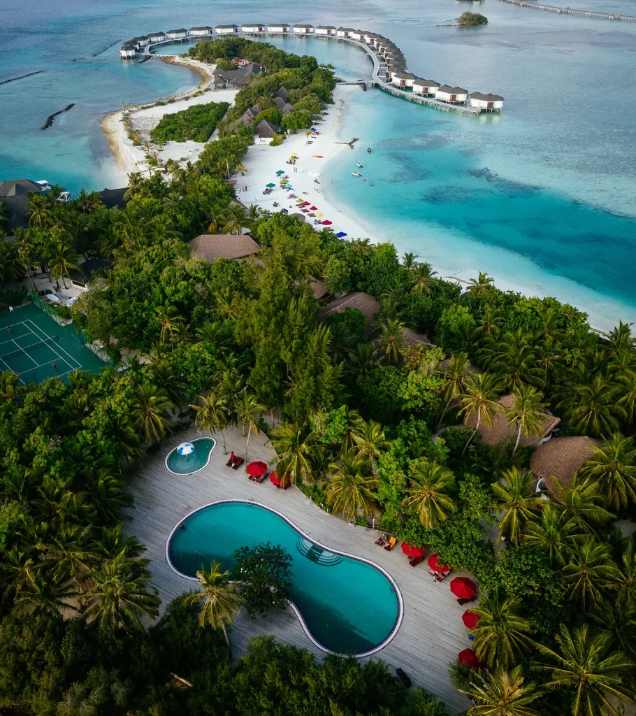 Surfer riding tall wave with spray in tropical sun, Maldives – Atoll Travel