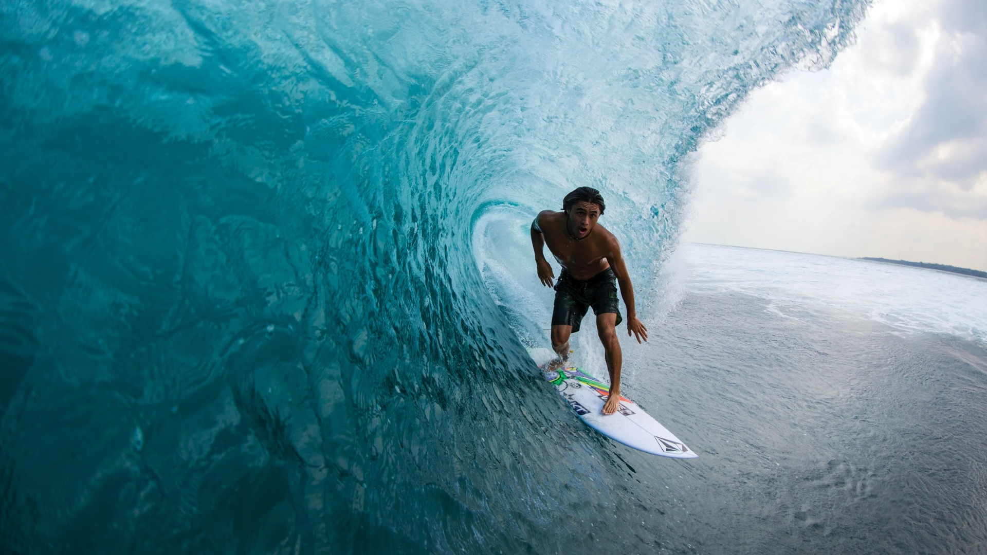 Surfer performing aerial maneuver over clear wave, Maldives – Atoll Travel